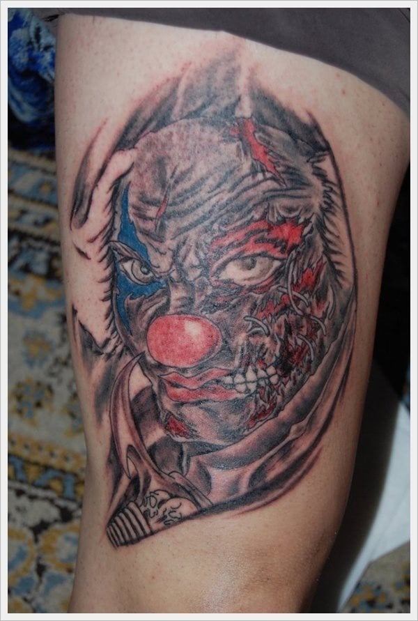 Otro tétrico tattoo en tonos rojos y azules formado por un payaso un tanto enfadado, que tiene la cara desgarrada y la boca rota dejando a ver unos grandes dientes blancos