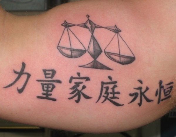 Tatuaje de una balanza sobre unas letras chinas