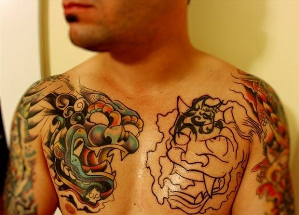 Tatuaje sobre el pecho y los brazos cuyos diseos principales son dragones asiticos