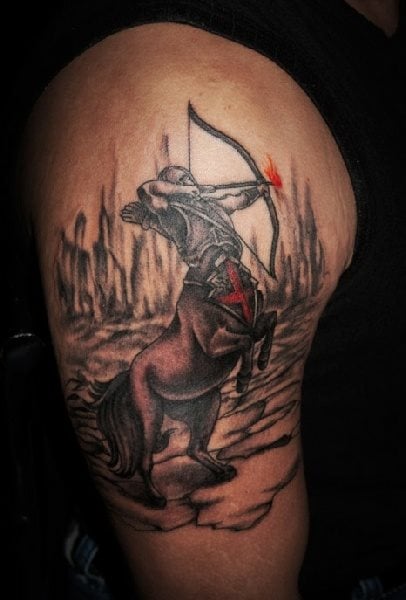 Tatuaje de un centauro tirando una flecha en llama, del tatuaje que aquí tenemos nos gustaría destacar que el fondo ha quedado muy bien y que el detalle de la armadura del centauro con el escudo con una cruz roja, luce muy bien en este tattoo
